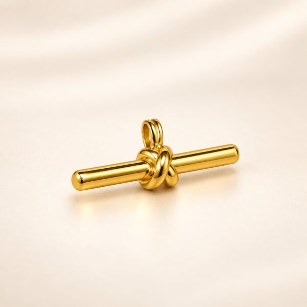 Angled view of Aurelia Knot Bar Pendant showing polished gold-tone bar and intertwined knot detail