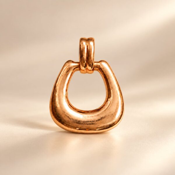 Seraphine Heritage Loop Pendant in a polished rose-gold finish on a warm cream background