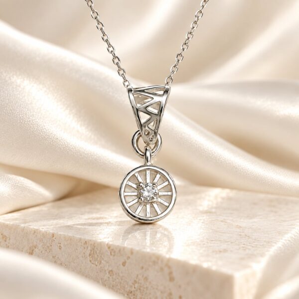 Meridian Halo silver-tone pendant hanging against ivory satin above cream marble